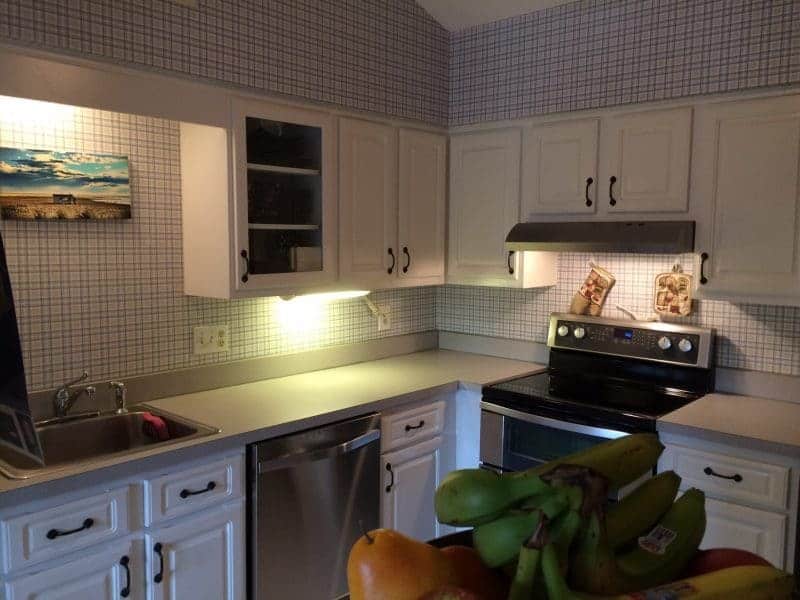 Kitchen with blue laminate countertops and updated stainless steel appliances.