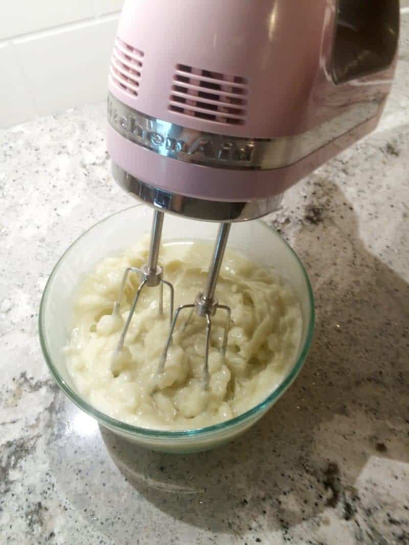 Hand mixer beating the mixture in the bowl.