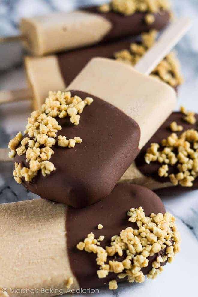 Chocolate and peanut butter popsicles dipped in chocolate and sprinkles with peanuts.