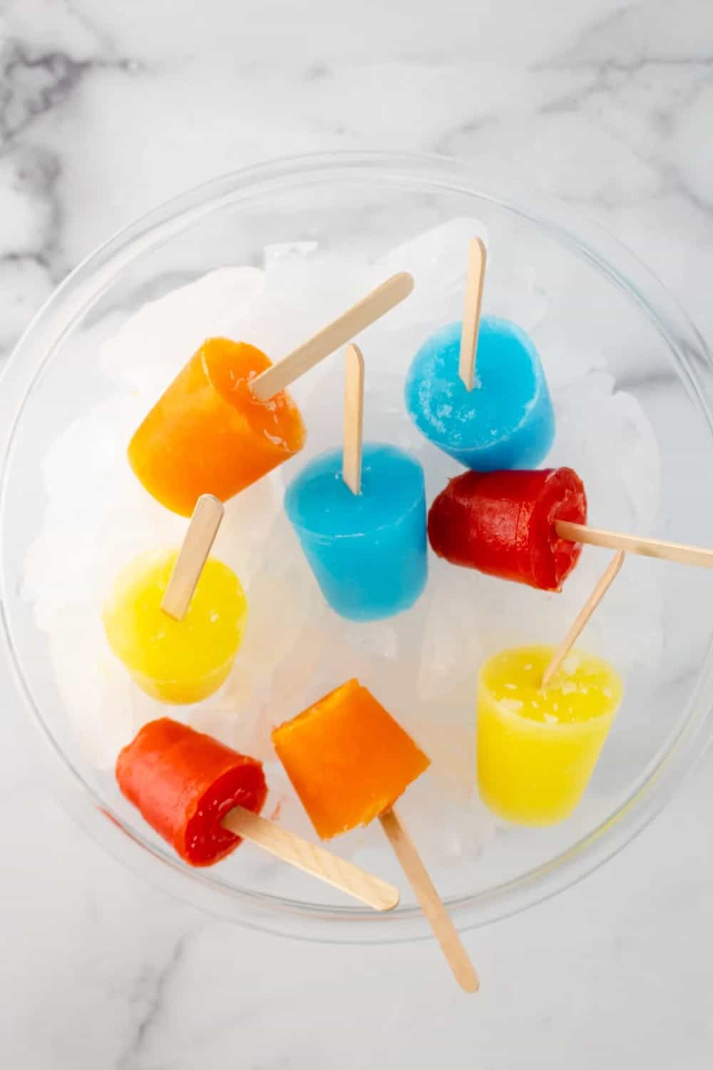 Orange, red, yellow and blue Jello Popsicles.