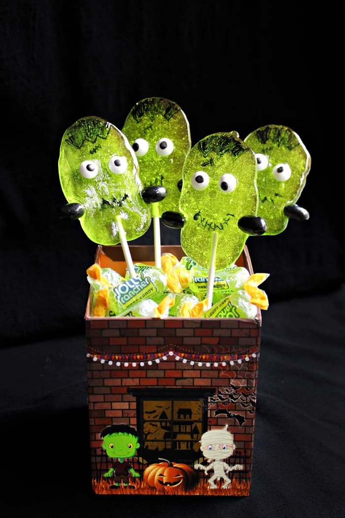 You don't need lightning or a fancy laboratory to make these adorable Halloween creations. These cute Frankenstein Suckers are made using Green Apple Jolly Ranchers!