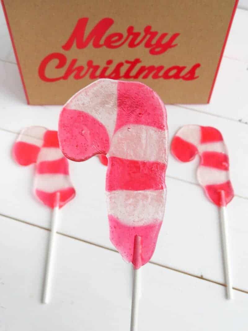 Candy Cane Lollipop on white stick close up with 2 more in background.