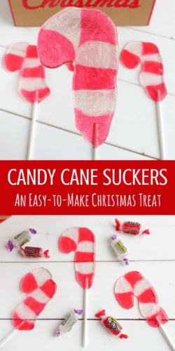 Candy cane shaped suckers on white wood background with strawberry and pineapple jolly rancher candies scattered around.