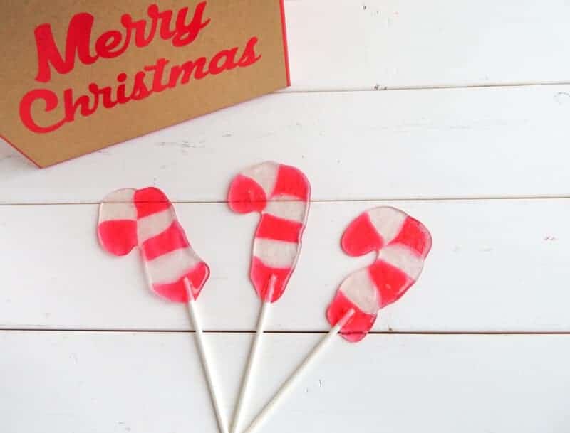 Candy Cane Suckers on white wood background.