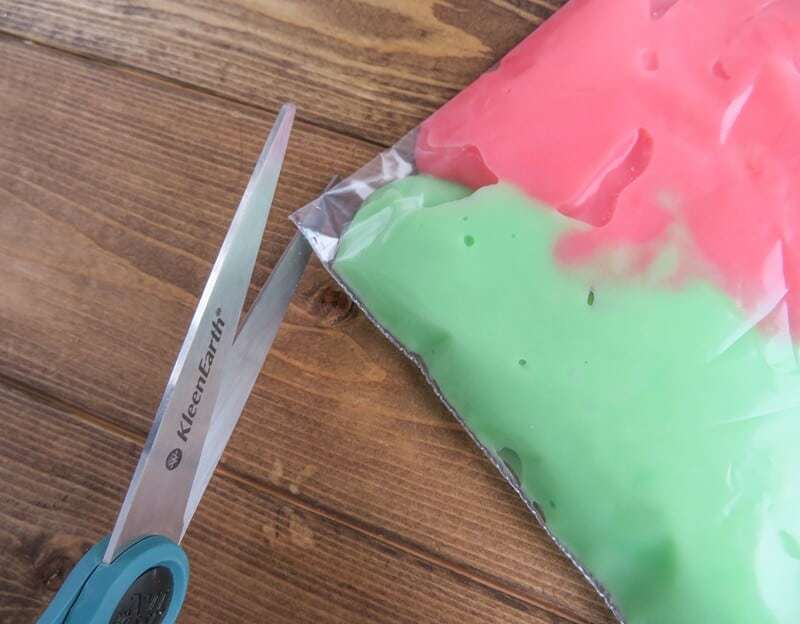 Small corner of tip being cut off baggie with scissors.