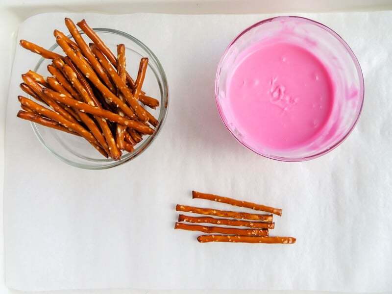 Pretzel sticks and melted pink candy.
