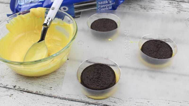Oreo cookies placed on top of yellow candy in mold.