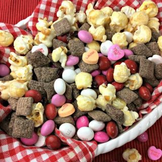 Valentine's Day snack mix made with cherry muddy buddies, popcorn, and candies.