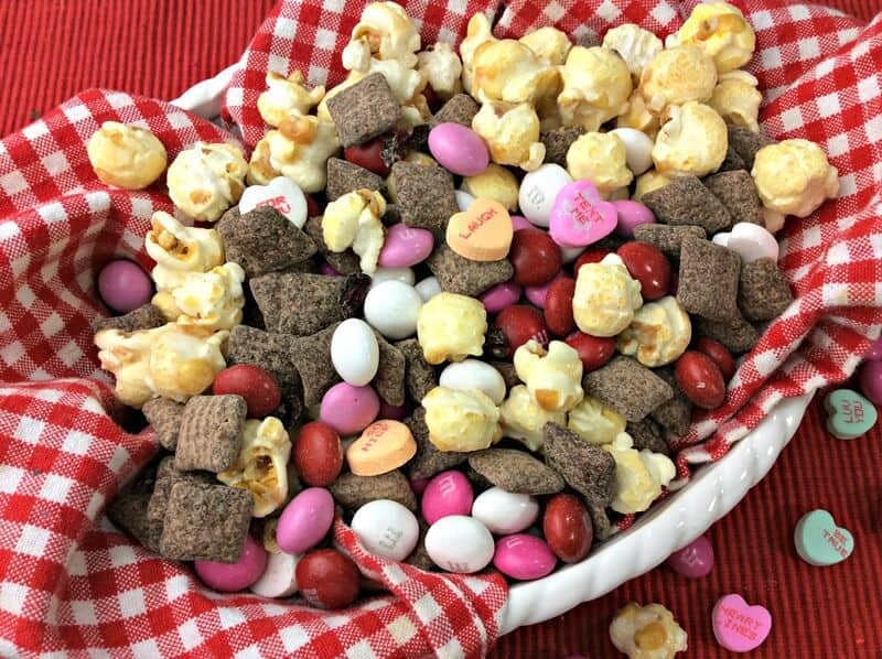 Valentine's Day snack mix with popcorn, conversation heart candies, M&Ms, and homemade cherry muddy buddies.
