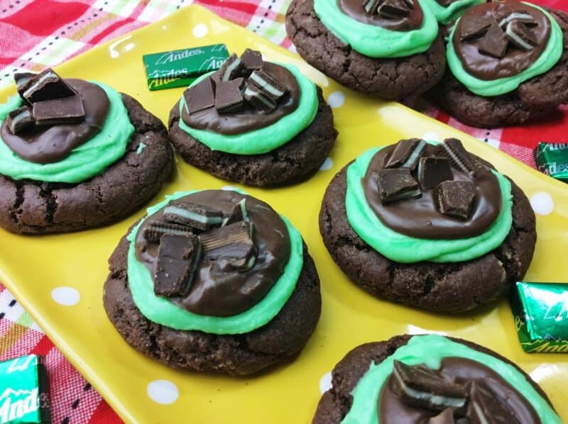 Chocolate cookies topped with minty green frosting, chocolate, and pieces of andes mint candies.