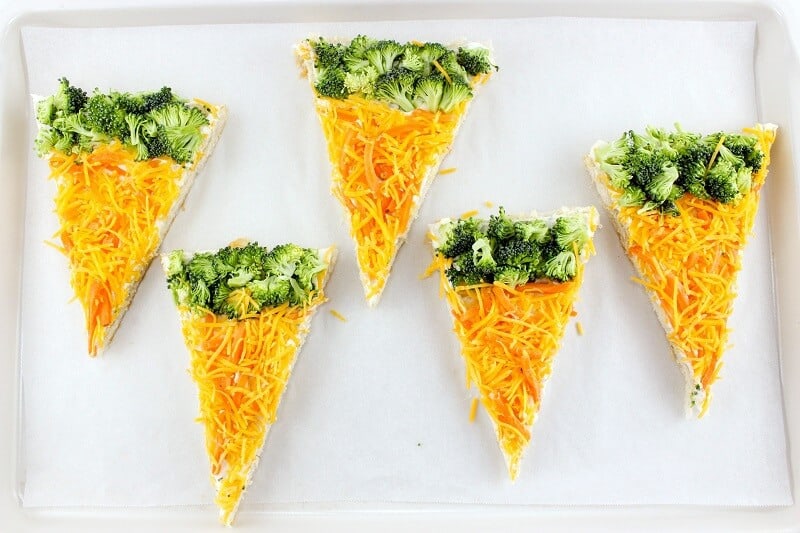 Slices of carrot and broccoli veggie bars on baking sheet.