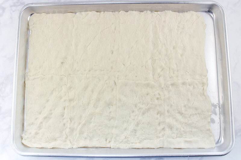Crescent roll dough spread onto baking sheet.