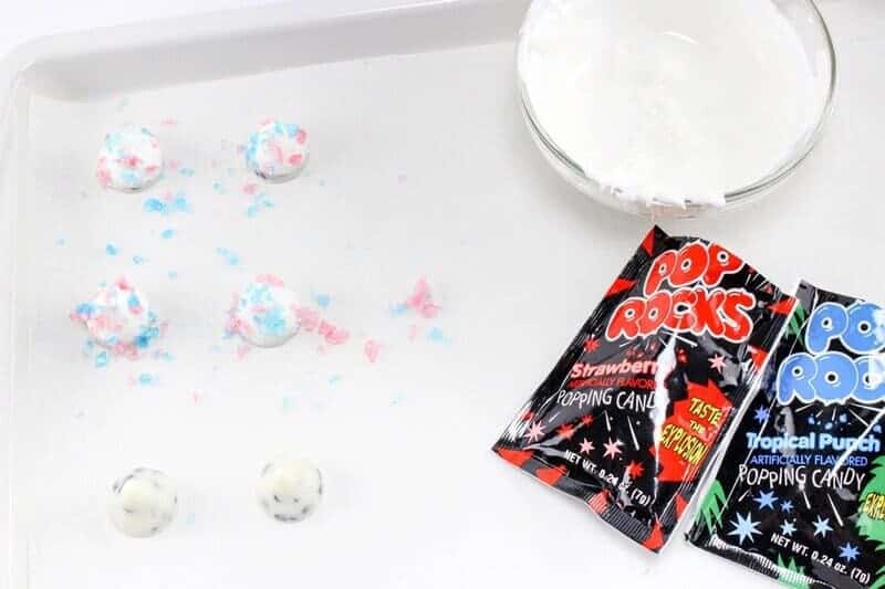 Pop Rocks popping candy being sprinkled on top of white hershey kisses.