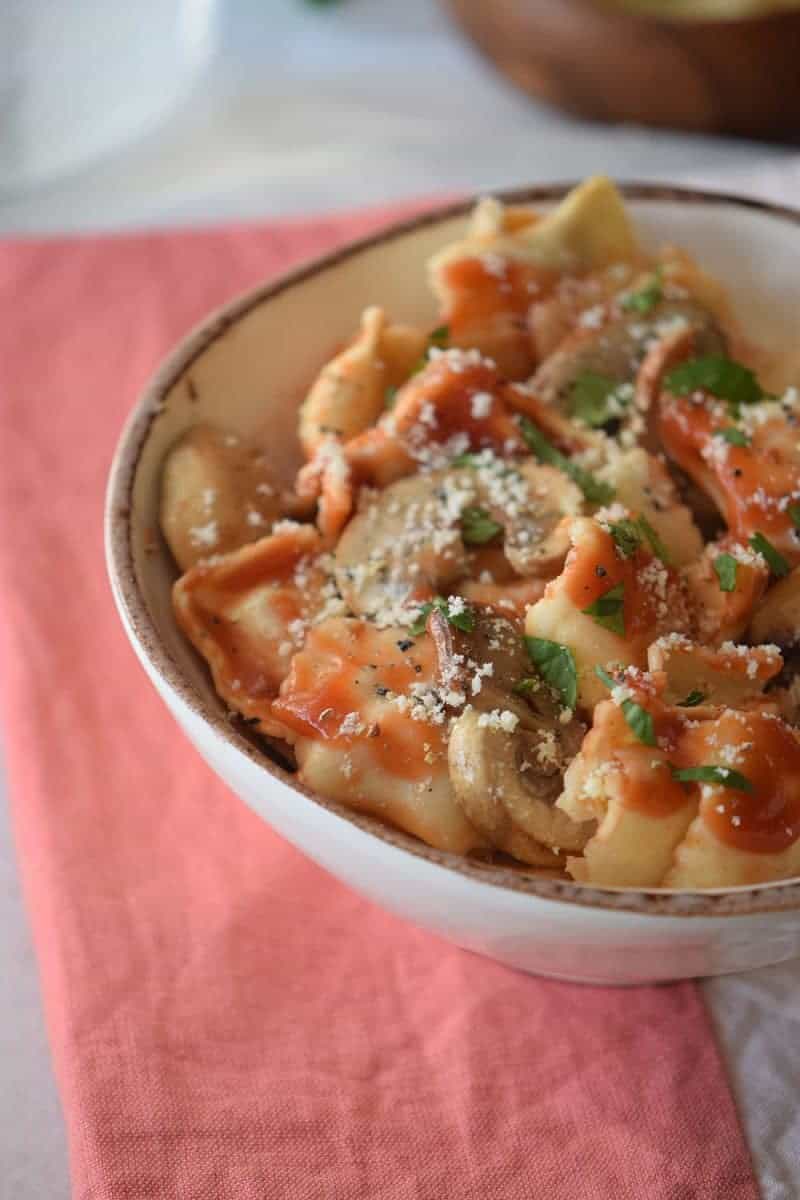 Bowl of ravioli with mushroom sauce.