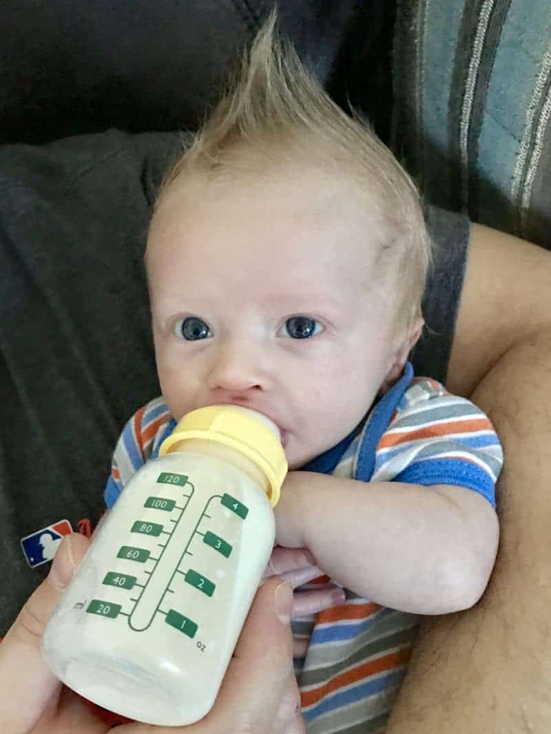 Baby Drinking 4 ounce bottle of formula.