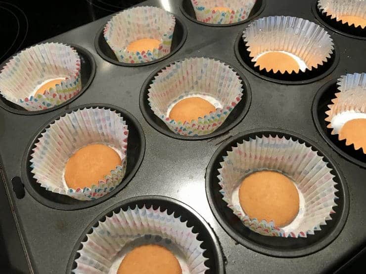 Cupcake tin filled with cupcake liners with Nilla wafers in the center.
