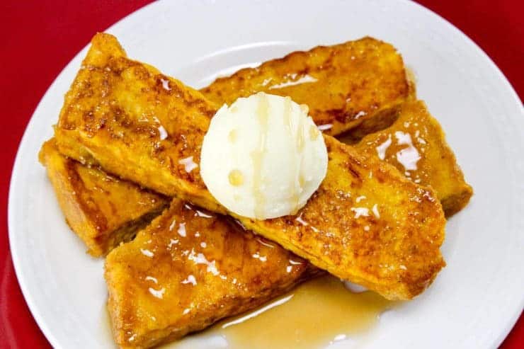 Prepared pumpkin french toast sticks served with butter and maple syrup.