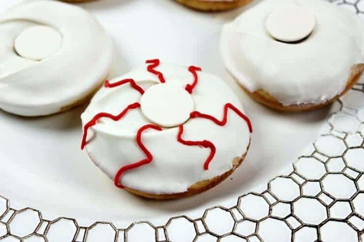 Red squiggly lines of icing drawn on donut to look like bloodshot eyes.