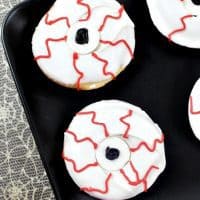 Bloodshot monster eyeball donuts on black plate.