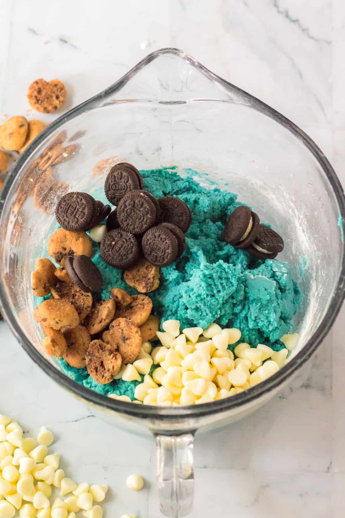 Blue cookie dough in mixing bowl with mix-ins added.