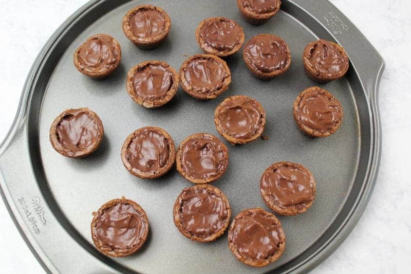 Brownie bites filled with chocolate pudding on tray.