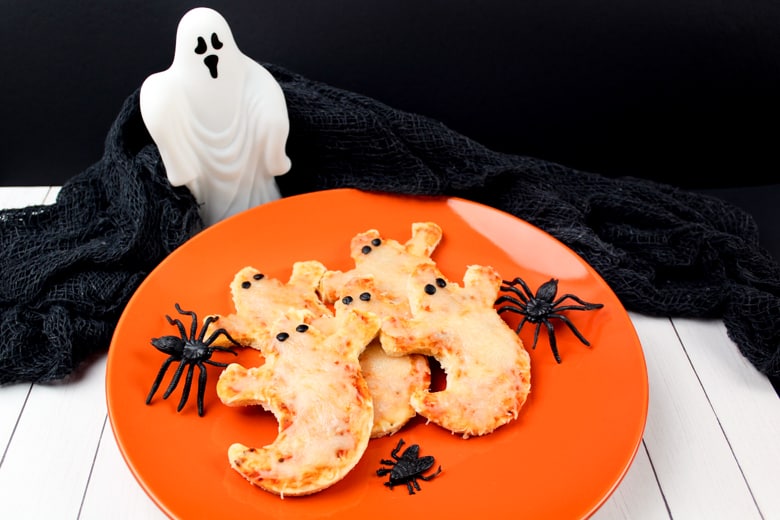 Mini Ghost Pizzas served on an orange plate.