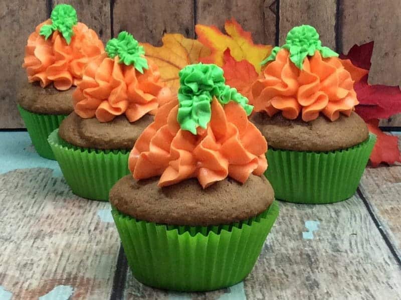 Pumpkin cupcakes made with buttercream pumpkin design on top.