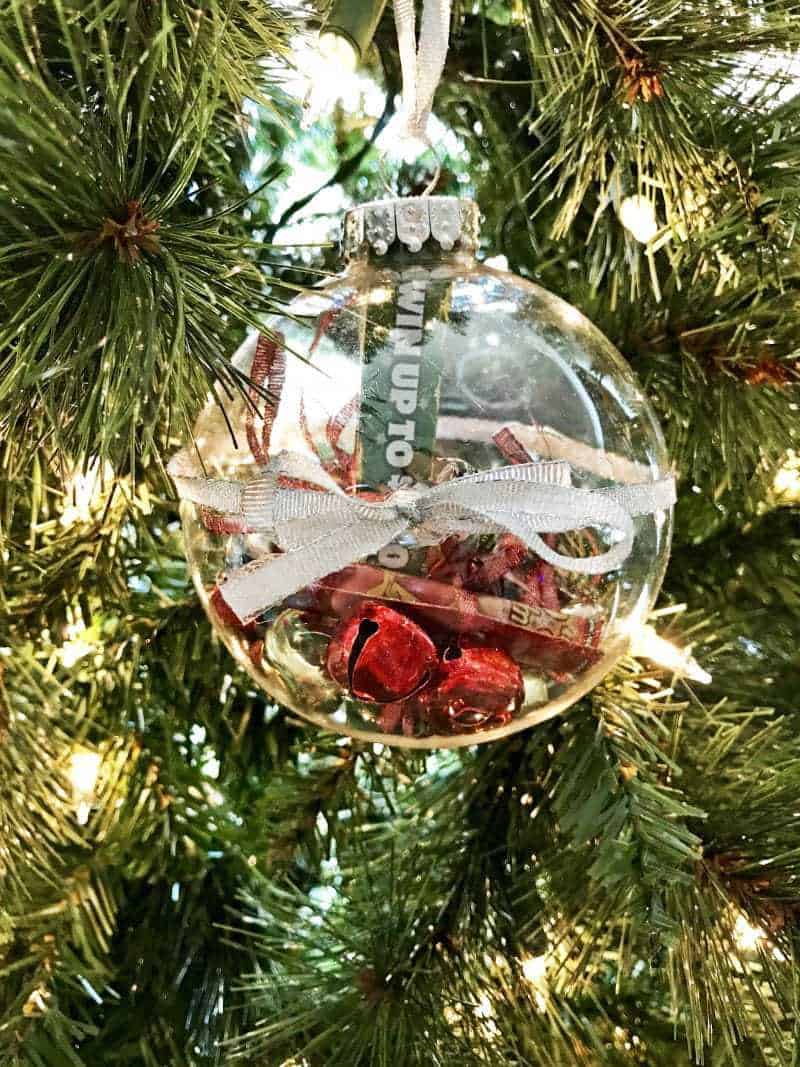 Clear ball ornament with lottery ticket scratch offs and jingle bells inside.