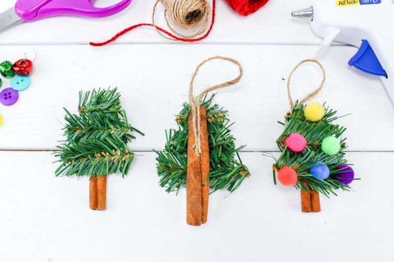 A fun DIY Christmas Tree Ornament craft, made using wreath garland, cinnamon sticks, twine, buttons, pom poms and jingle bells.