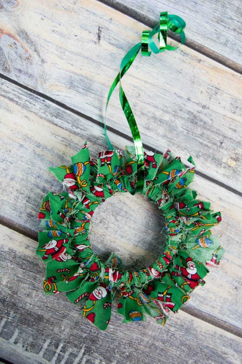 Mason canning jar lid Christmas wreath ornaments are great  for giving your tree that homemade rustic feel, and can be customized with any color fabric.