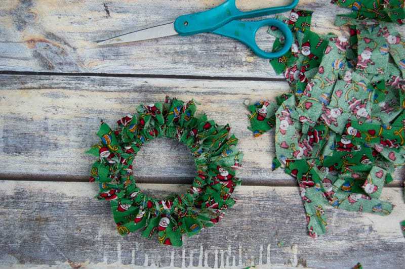 Mason canning jar lid Christmas wreath ornaments are great  for giving your tree that homemade rustic feel, and can be customized with any color fabric.