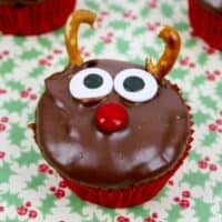 Reindeer cupcakes with chocolate frosting, red candy nose, candy eyes, and pretzel antlers.