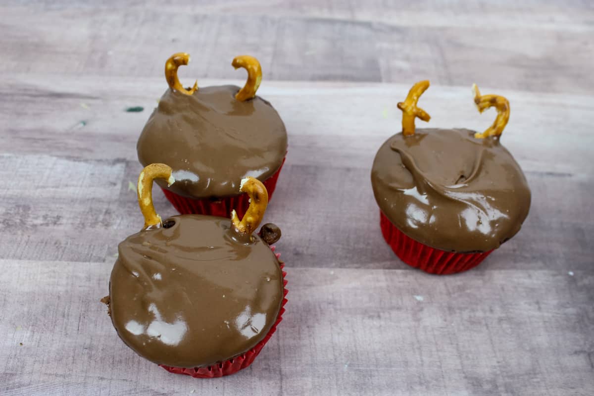 Chocolate cupcakes with pretzel antlers pressed into top.