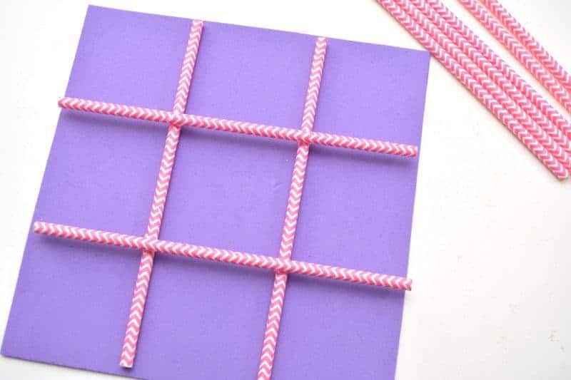 This DIY Tic Tac Toe board game is an easy Valentine's Day homemade craft for the kids to make using a foam sheet, paper straws, and pink and red hearts.