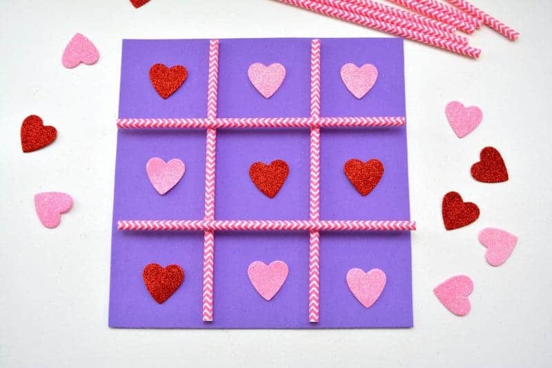 This DIY Tic Tac Toe board game is an easy Valentine's Day homemade craft for the kids to make using a foam sheet, paper straws, and pink and red hearts.