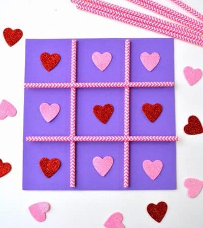 This DIY Tic Tac Toe board game is an easy Valentine's Day homemade craft for the kids to make using a foam sheet, paper straws, and pink and red hearts.