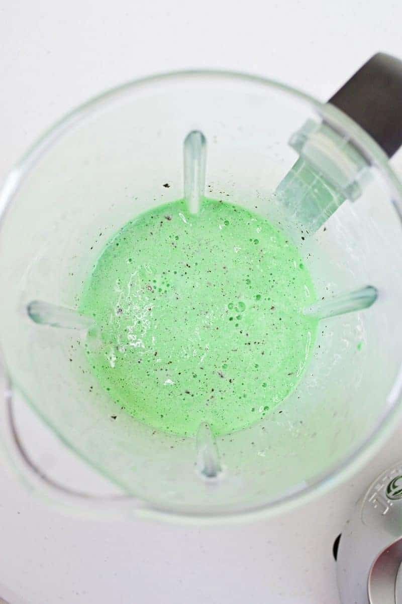 Bright green mint chocolate chip milkshake blended in blender