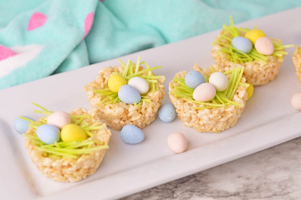 Four Rice Krispie Easter Nests on a white serving platter.