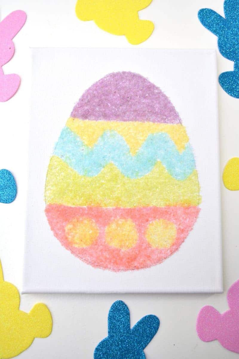 Salt glitter is fun to make and use in arts & crafts projects like this colorful salt glitter Easter egg canvas. Find out how to make homemade salt glitter with this step-by-step tutorial. 