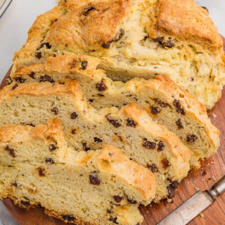 Sliced Irish soda bread with raisins on a wooden board