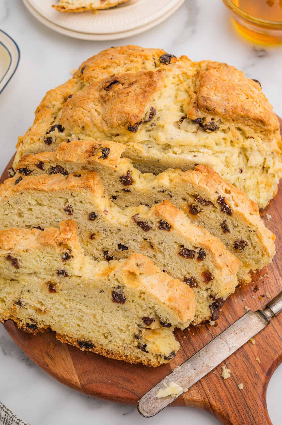 Sliced Irish soda bread with raisins on a wooden board