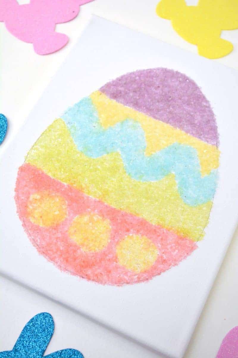 Salt glitter is fun to make and use in arts & crafts projects like this colorful salt glitter Easter egg canvas. Find out how to make homemade salt glitter with this step-by-step tutorial. 