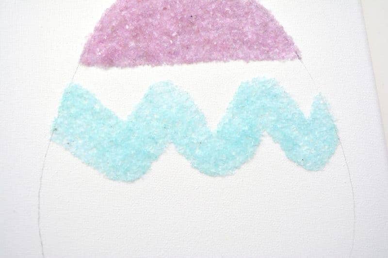 Salt glitter is fun to make and use in arts & crafts projects like this colorful salt glitter Easter egg canvas. Find out how to make homemade salt glitter with this step-by-step tutorial. 