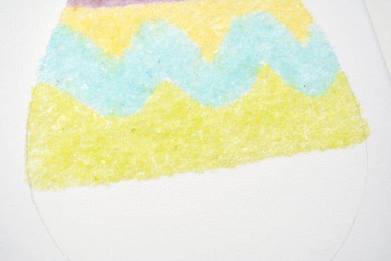 Salt glitter is fun to make and use in arts & crafts projects like this colorful salt glitter Easter egg canvas. Find out how to make homemade salt glitter with this step-by-step tutorial. 