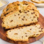 Homemade Irish soda bread with raisins and caraway seeds on a cutting board.