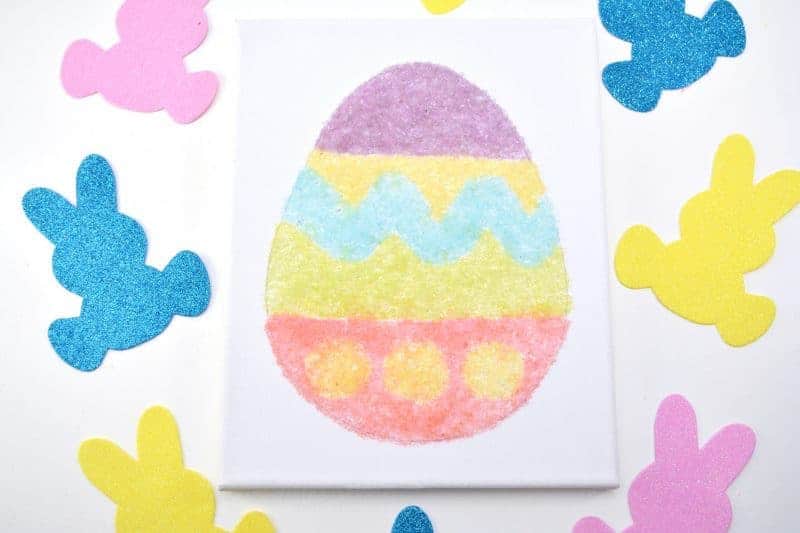 Salt glitter is fun to make and use in arts & crafts projects like this colorful salt glitter Easter egg canvas. Find out how to make homemade salt glitter with this step-by-step tutorial. 