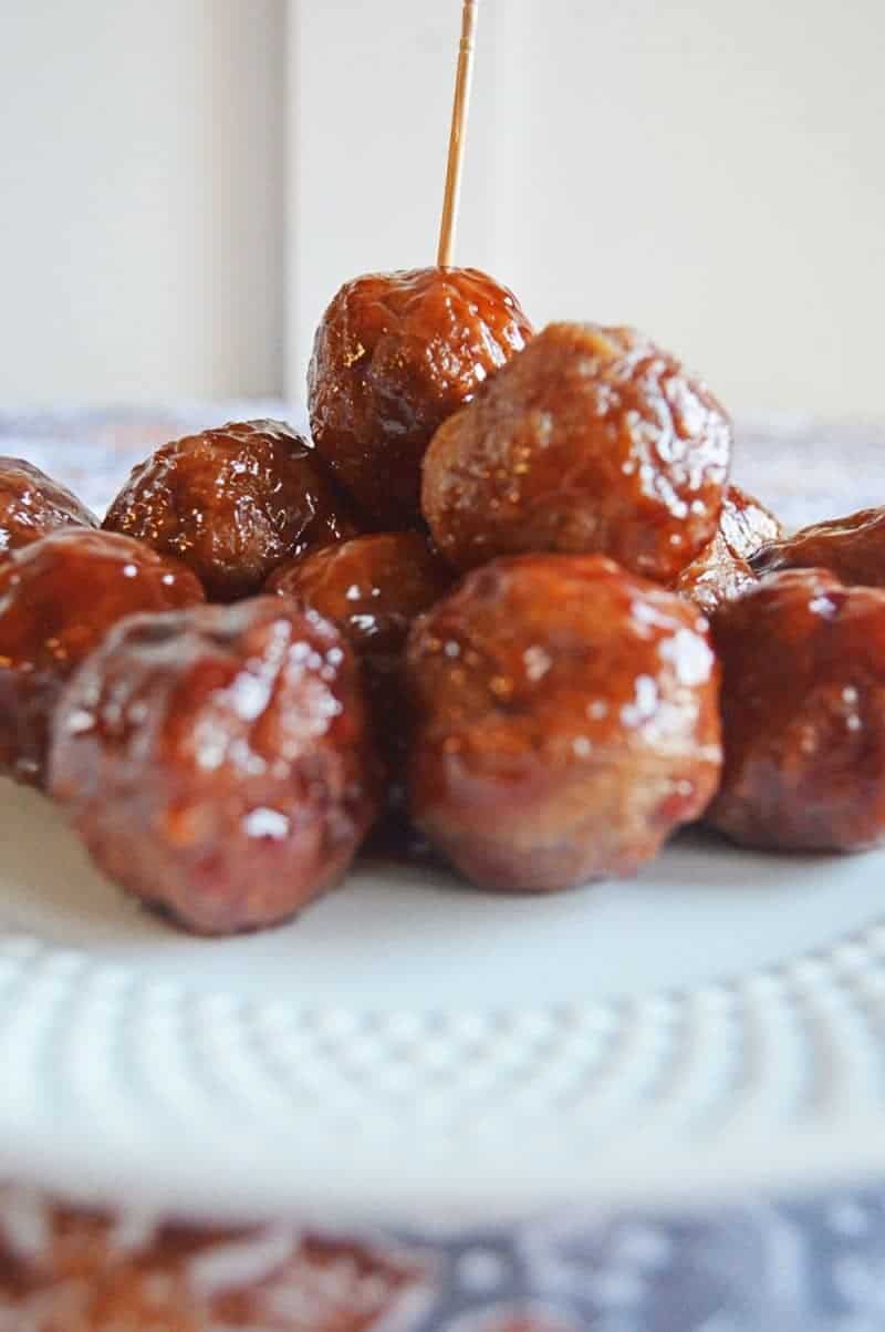 Crockpot BBQ grape jelly meatballs served on a plate with toothpicks.