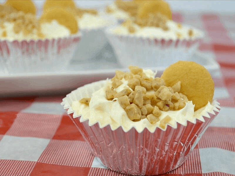 individual cheesecakes in cupcake liners topped with toffee bits and garnished with a cookie