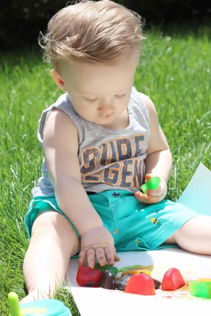 This colored ice play activity using ice cubes colored with drink mix makes for a  fun, low cost, and easy outdoor sensory activity for little ones.