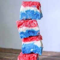 A red, white, and blue marshmallow creme fudge recipe made with marshmallow creme, evaporated milk, white chocolate chips, sugar, butter, and food coloring.